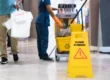 Janitorial worker with cleaning cart and caution sign showing how to choose a janitorial service in Phoenix