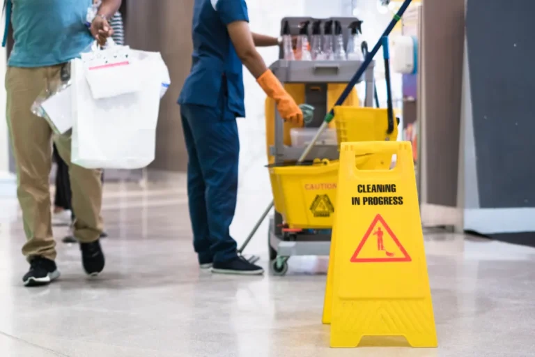 Janitorial worker with cleaning cart and caution sign showing how to choose a janitorial service in Phoenix